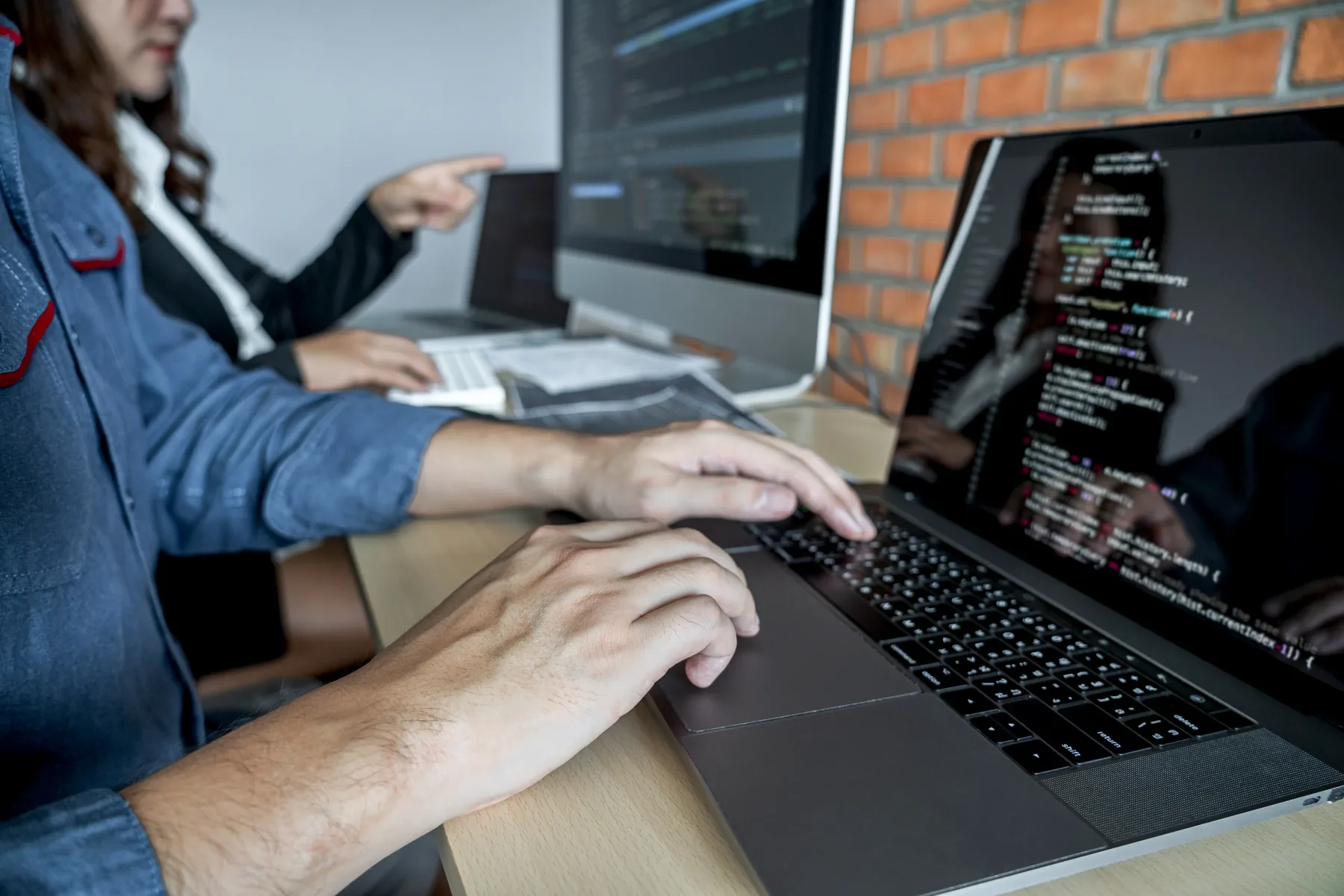 Developers collaborating around code and a laptop