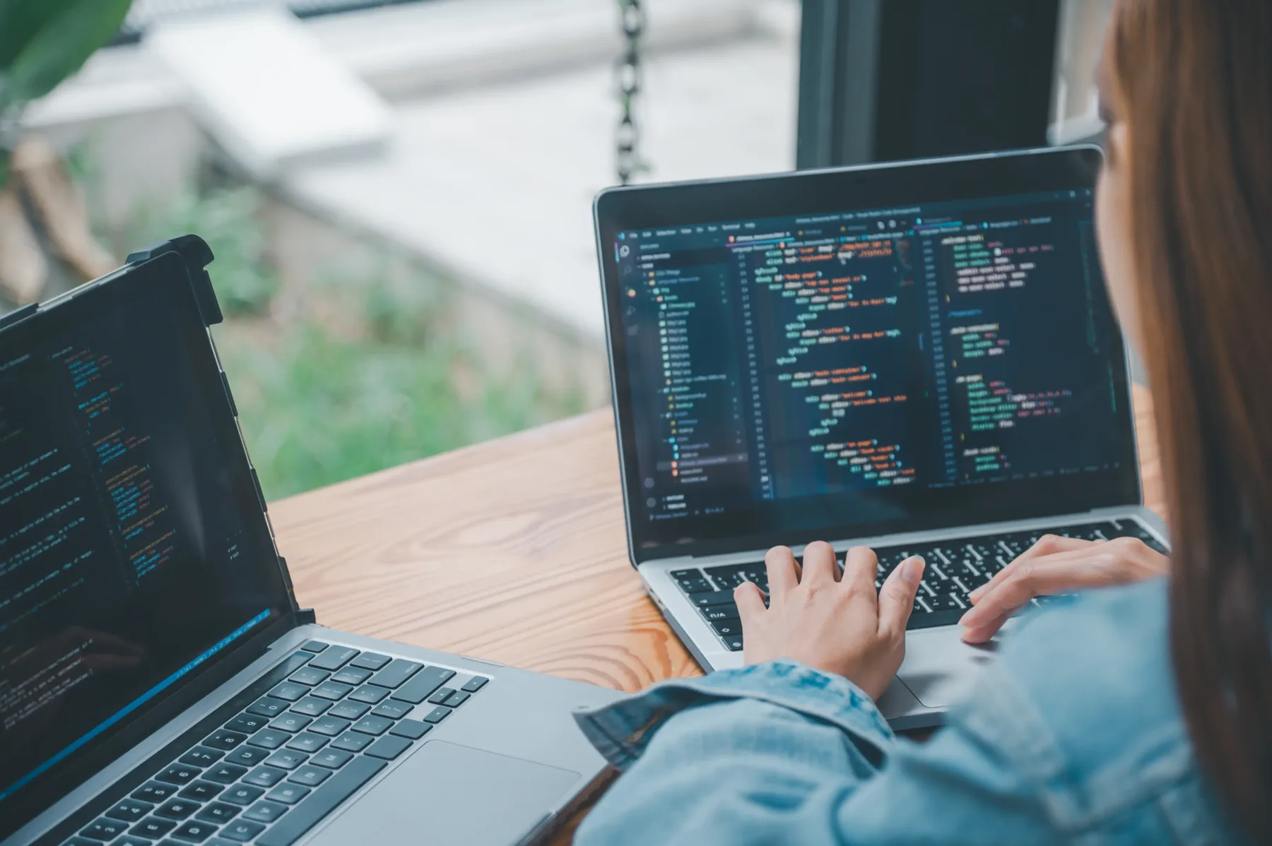 Developer working on a laptop with code visible on screen